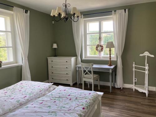 una camera con letto, scrivania e finestra di Apartmán Nad Modravou a Modrava