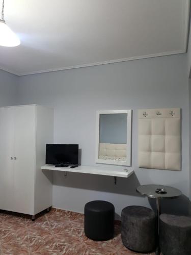 a room with a table and two stools and a mirror at Villa Crystal in Sarandë