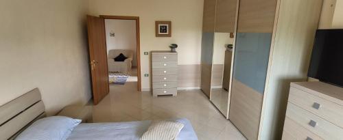 a bedroom with a bed and a dresser and a mirror at BELLISSIMA CASA AL MARE CON VISTA MOZZAFIATO in Golem
