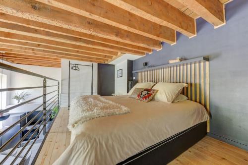 a bedroom with a large bed and wooden ceilings at Appartement de prestige - "Big Surf" in Caluire-et-Cuire
