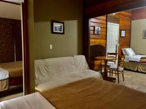 a bedroom with a bed and a mirror and a table at Merritt Lodge in Merritt