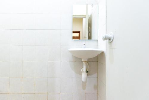 a white bathroom with a sink and a mirror at RedDoorz near Kelapa Gading in Jakarta