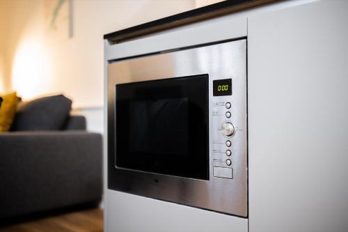 a microwave oven sitting next to a couch at Charming 60m2 One-Bedroom Apartment in Tiel