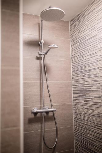 a shower with a shower head in a bathroom at Charming 60m2 One-Bedroom Apartment - WE39B in Tiel