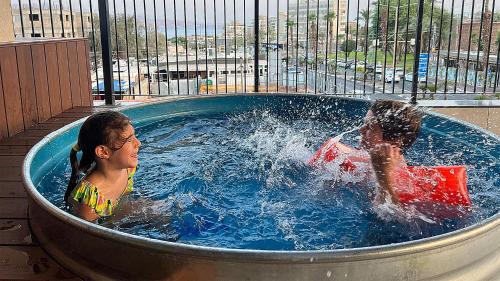 2 jeunes enfants jouant dans un bain à remous dans l'établissement Mr. Soof - By TLV2GO, à Eilat