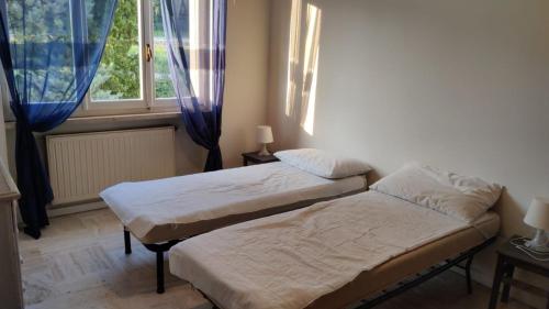2 Einzelbetten in einem Zimmer mit Fenster in der Unterkunft Appartamento per 4 persone - Caray Park - Sale Marasino - Lago d'Iseo in Marone