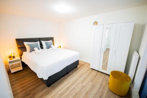 1 dormitorio con 1 cama blanca grande y suelo de madera en Friendly 50m2 One-Bedroom Apartment, en Tiel