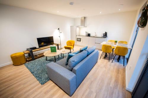 a living room with a blue couch and yellow chairs at Friendly 50m2 One-Bedroom Apartment - WE39A in Tiel