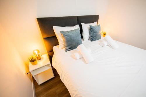 a bedroom with a large white bed with blue pillows at Friendly 50m2 One-Bedroom Apartment - WE39A in Tiel