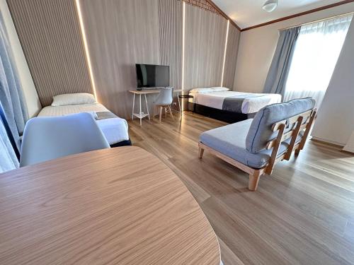a hotel room with two beds and a chair and a table at Spa Village Travel Inn in Moree