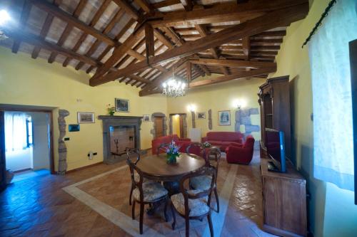 a living room with a table and chairs and a tv at Agriturismo Buriano in Lubriano