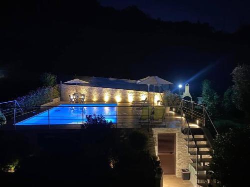 a swimming pool lit up at night with lights at Appartamento con piscina e idromassaggio a 5 min dal mare in Santa Veneranda