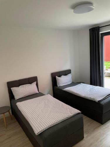 - 2 lits dans une chambre avec fenêtre dans l'établissement A1 Unterkunft, à Hollenstedt