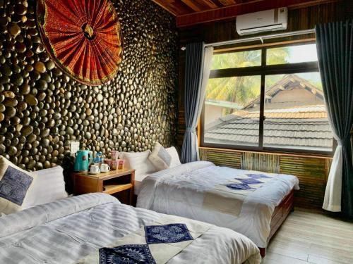 een hotelkamer met 2 bedden en een raam bij Mai Chau Moonlight Ecohouse in Mai Chau