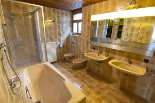 a bathroom with two sinks and a shower and two toilets at Charmante Bauernhofwohnung in Lautertal in Lautertal