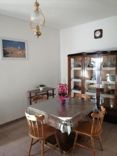 a dining room with a table with chairs and a cabinet at I Trecento in Padula