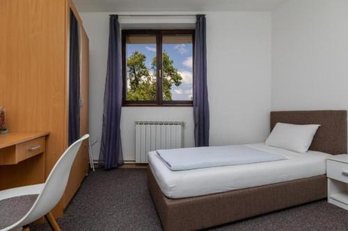 ein kleines Schlafzimmer mit einem Bett und einem Fenster in der Unterkunft Apartment Karlovac in Karlovac