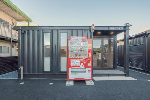 una parada de autobús con un cartel delante en HOTEL R9 The Yard Togane, en Tōgane