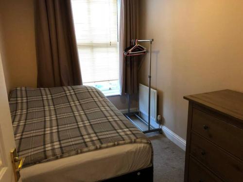 - une petite chambre avec un lit et une fenêtre dans l'établissement London SW19 2 bed 2 bath private flat, à Londres