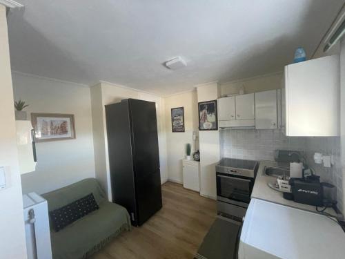 a small kitchen with a black refrigerator in a room at ParkSide Loft in Kalamata
