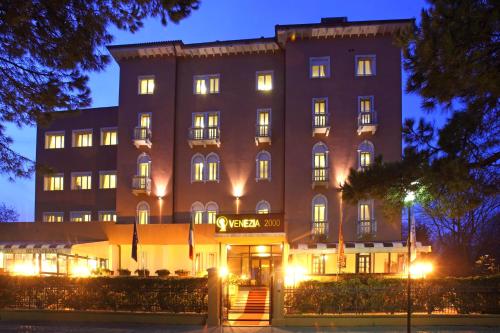 un grand bâtiment avec des lumières devant lui dans l'établissement Hotel & Residence Venezia 2000, sur le Lido de Venise