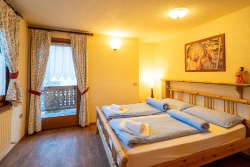 a bedroom with two beds and a window at Residence L'Arcobi in Livigno