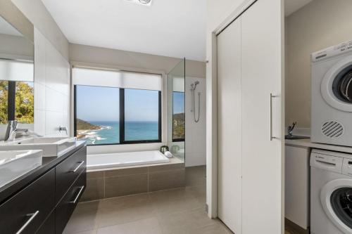 a bathroom with a sink and a washing machine at Azure in Wye River