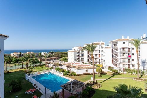 an apartment with a swimming pool and palm trees at 210 Mijas Sea View Bahia Playa in La Cala de Mijas