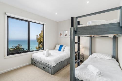 a bedroom with two bunk beds and a window at Azure in Wye River