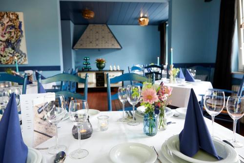 - une table avec des assiettes blanches et des verres à vin dans l'établissement Gästehaus am Landhaus Friedrichsfehn, à Edewecht