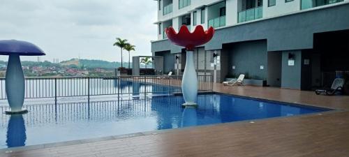a swimming pool with a red flower on top of a building at Melangok Homestay in Kajang