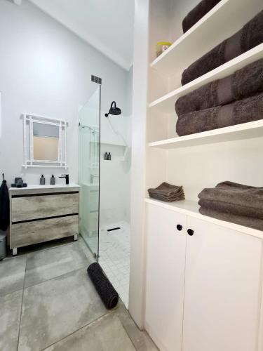 a bathroom with a glass shower and a sink at Victoria's Place in Kenton on Sea
