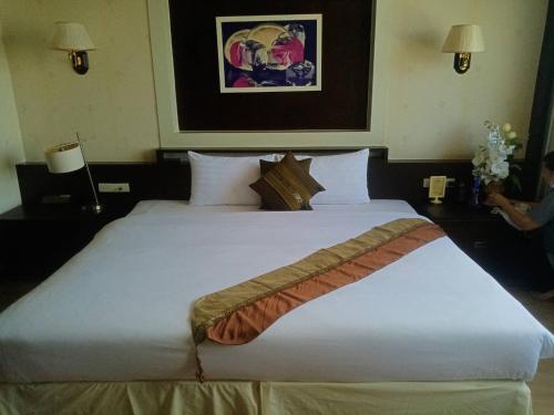 a large white bed in a hotel room at Grand Phranakhon Hotel in Phra Nakhon Si Ayutthaya