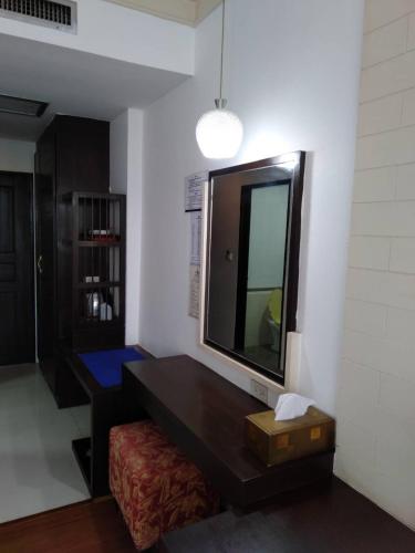a living room with a table and a mirror at Grand Phranakhon Hotel in Phra Nakhon Si Ayutthaya