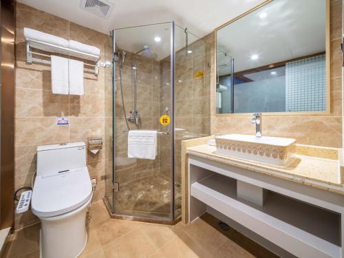 La salle de bains est pourvue de toilettes, d'une douche et d'un lavabo. dans l'établissement Yiwu Defeng Hotel, à Yiwu