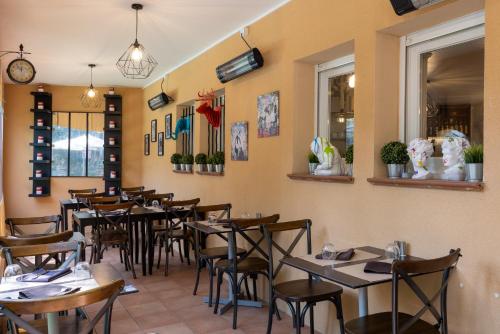 アロッシュにあるThe Originals City, Hôtel Côté Sud, Marseille Est (Inter-Hotel)のテーブルと椅子が備わるレストラン