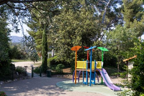 a playground with a slide in a park at The Originals City, Hôtel Côté Sud, Marseille Est in Allauch
