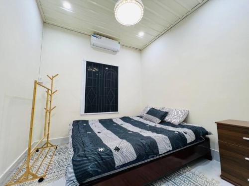 a bedroom with a bed in a white room at Charis Home- Tay Ninh in Tây Ninh
