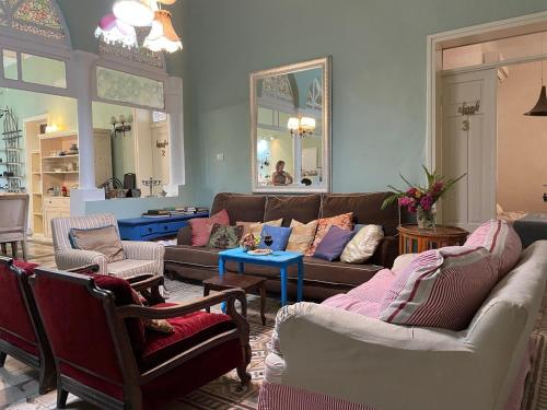 a living room with couches and chairs and a mirror at Villa Marina in Haifa