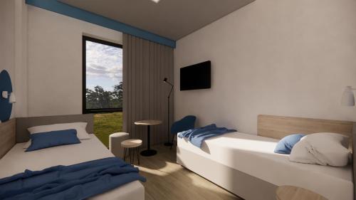 1 dormitorio con 2 camas y ventana en Hotel Active Stadium en Lovosice