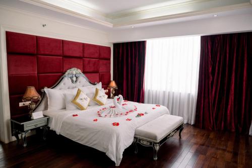 una camera con un grande letto con testiera rossa di Moonlight Hotel Hue a Hue