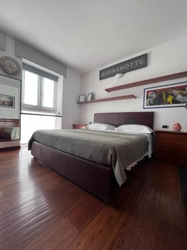 a bedroom with a large bed and a wooden floor at Casa vacanze Attico sul lago di Lecco, a due passi dal centro con posto auto in Lecco