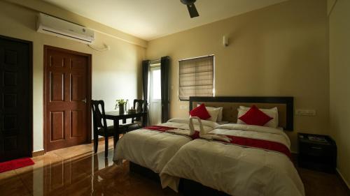 a bedroom with a large bed with red pillows at Oryx Home The Business Class Hotel in Kakkanad