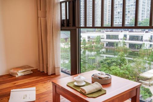 a room with a table and a large window at Taihua Wutong Apartment in Bao'an