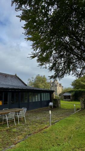 a picnic table and chairs in front of a building at Le Gîte les NUZ ( parc du château de Keroüartz) in Lannilis
