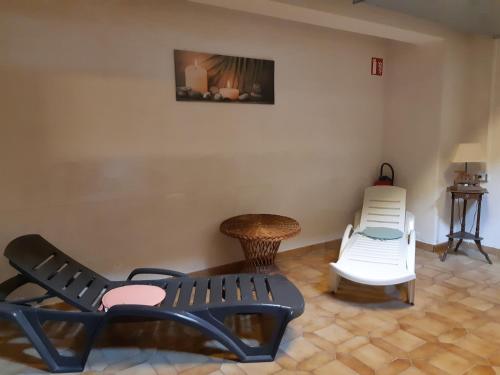 a room with two chairs and a bench and a table at Hotel-Spa & Restaurant Logis Domaine Langmatt in Murbach
