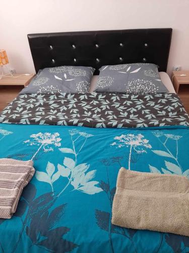 łóżko z niebieską kołdrą i poduszkami w obiekcie Szary Domek 2 w mieście Wieprz