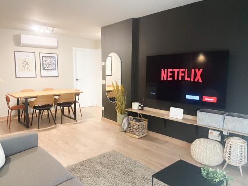 a living room with a television and a table with chairs at ¡Más céntrico imposible! 6PAX+PK in Andorra la Vella