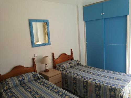 ベナルマデナにあるApartamentos Minerva JCのベッドルーム1室(ベッド2台、青いキャビネット付)