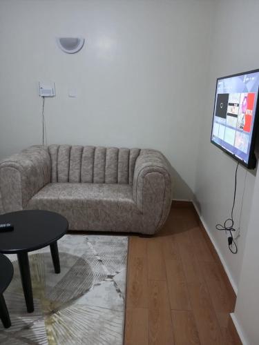 un soggiorno con divano e TV a schermo piatto di Lux Suites Wawazi Court Apartments a Nairobi